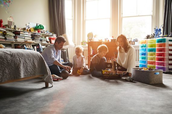 Shot of a mother and father playing with their two sons in their bedroom